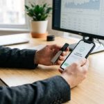 Hardware wallet beside a smartphone wallet app showing a security confirmation screen